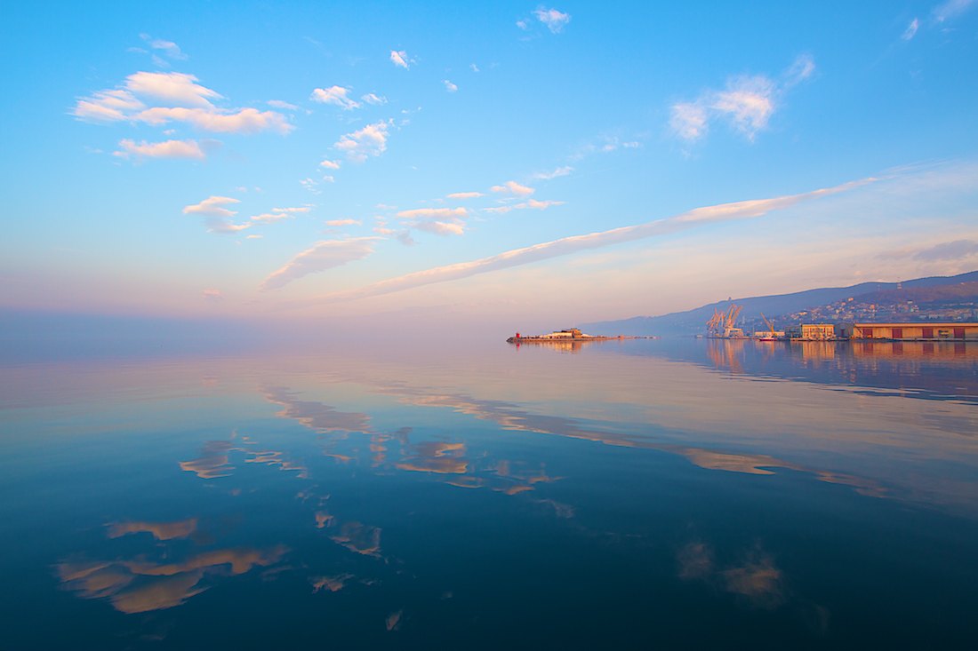 TRIESTE. Le nuvole e i colori del cielo all'alba, riflessi sul golfo di Trieste. Foto di Massimo Goina | STUDIOGOINA.IT